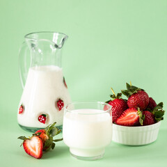 Milk and fresh strawberries on a green background. healthy diet and nutrition, lifestyle.