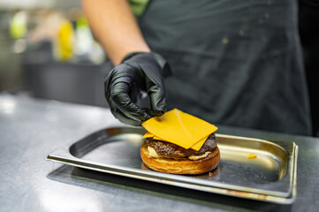 chef hand cooking burger on restaurant kitchen