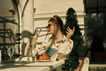 Adult girl enjoying the aroma of hot coffee in an outdoor café