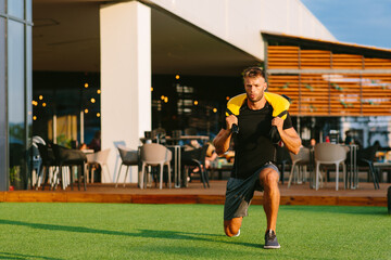 Handsome young man doing squats outside on a sunny day