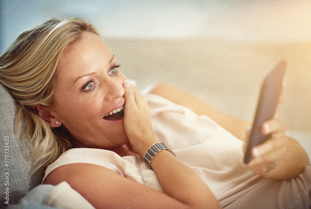 Poster whaaat. a mature woman looking surprised while reading a text message at home.