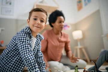Happy little boy playing in kindergarten and looking at camera.
