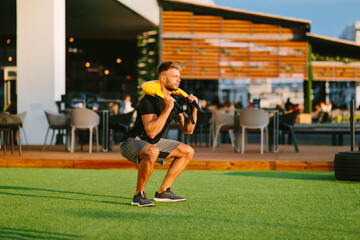 Handsome young man doing squats outside on a sunny day