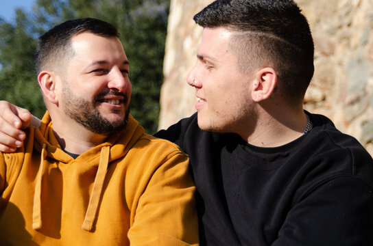 Two Men In Love Stare At Each Other While In A Park. Homosexuality And LGBTQ+ Concept.