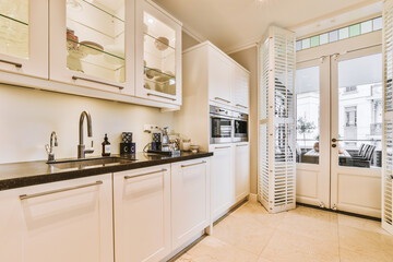 a kitchen with white cabinets and black counter tops on the floor in front of the door is an open...