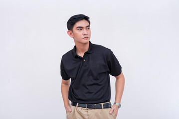 A pensive young and handsome professional looking to his side. A supervisor in a black polo shirt...
