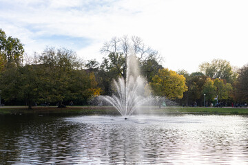 Naklejka premium Beautiful Pond and Fountain with Colorful Trees during Autumn at Vondelpark in Amsterdam