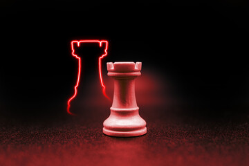 red crimson rook with led in the shape of a rook. close up photo with black background. chess piece...