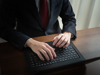 ノートパソコンで作業する男性