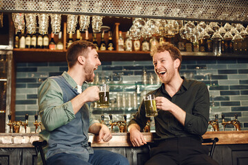 Men at bar behind bar with beer
