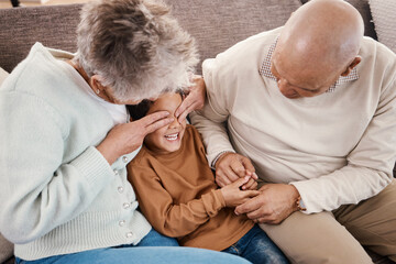 Love, grandparents and boy play on couch, happiness and bonding together for quality time. Family, granny and grandad with grandchild, playing and smile in living room, loving and enjoy retirement