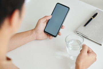 Man drinking water and reading news on social media