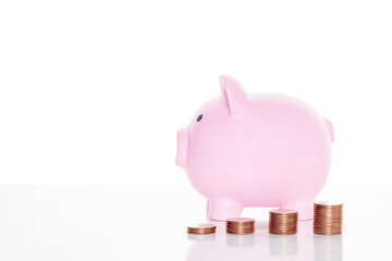 Pink piggy bank and stack of coins
