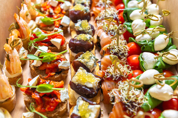 Delicious gourmet snacks for wine party delivered in cardboard box. Set of canape assortment for...