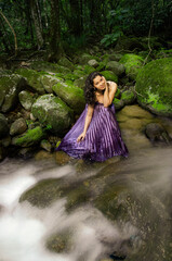 Fototapeta na wymiar Beautiful brunette woman in long dress in crystal clear creek in forest. Running water waterfall.