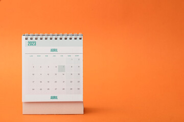 Desk calendar for the month of April 2023 with bright orange background