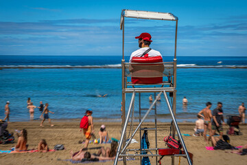 Am Stadtstrand von Las Palmas de Gran Canaria beobachtet ein Rettungsschwimmer das Treiben im...