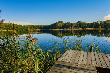 Beautiful sunset over lake with wooden pier.