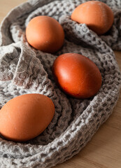 Brown eggs on a gray towel