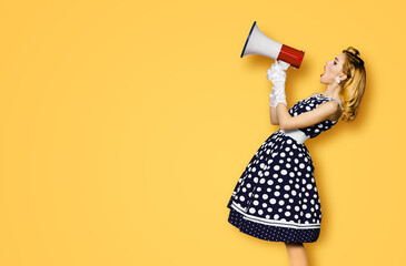 Profile side view image of beautiful woman hold mega phone, shout advertise some offer. Pretty girl in black pin up dress with megaphone loudspeaker. Isolated orange yellow background. Big sales ad.