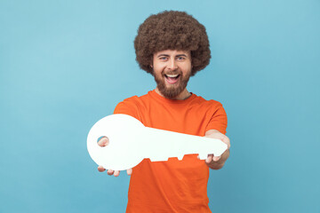 Man holding in hand big paper key as symbol of her own apartment, state housing program.