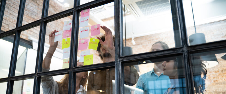 Brainstorm,Meeting,Business Strategy,collaboration,planning,team work and creative thinking concept.woman meeting her team with sticky notes in the office.creative man and Business woman group at work