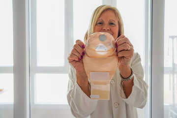 female doctor showing an ileostomy bag. international colon cancer day