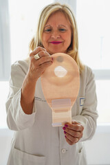 World international colon and intestine cancer. oncology female doctor looking at ileostomy bag.