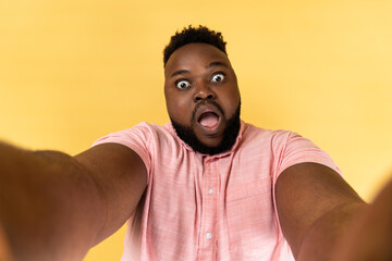 Man making point of view photo, having surprised expression, POV, looking at camera with open mouth.
