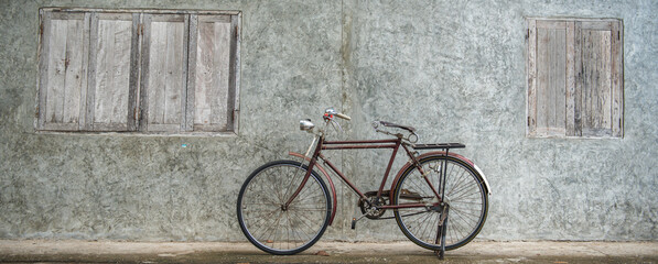 Banner panorama size of Vintage bicycle on old rustic dirty wall house, many stain on wood wall....