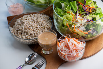 Hand cut and slice fresh baby cos salad on wood board table .Organic Vegetables mix lunch with green vegetables at kitchen table on wood cutting board.