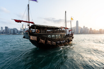boat with hong kong city skyline during sunset