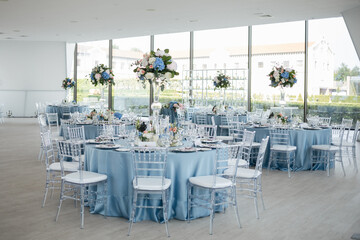 Served wedding table with decorative fresh pink, blue flowers and candles. Celebration details. Wedding decoration and decor, floristic concept