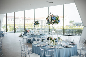 Served wedding table with decorative fresh pink, blue flowers and candles. Celebration details. Wedding decoration and decor, floristic concept