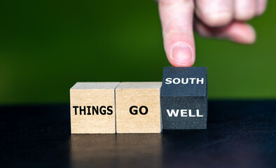 Hand turns wooden cube and changes the saying 'things go well' to 'things go south'.