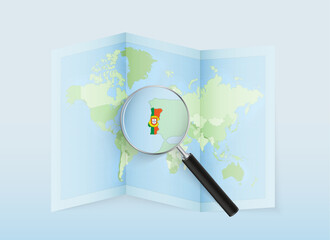 A folded world map with a magnifying lens pointing towards Portugal. Map and flag of Italy in loupe.