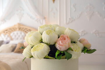 artificial bouquet of flowers in a box - an element of decorating a bright bedroom