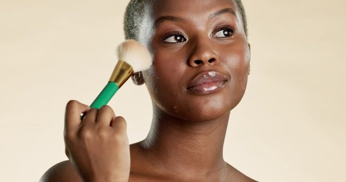 Black woman, face and brush for makeup, beauty and confidence with cosmetic tools on studio background. Attitude, portrait and mockup space with cosmetics, powder or foundation with female model hand