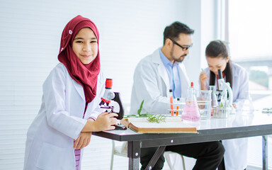 Asian little girl wearing hijab, headscarf, white ground uniform, studying Science in class room at...