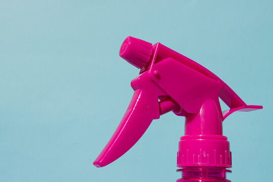 Pink atomizer on blue background