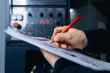 Engineer takes readings and controls manufacturing process on CNC conveyor machine for production...