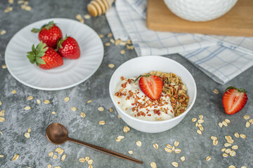 Healthy food concept: homemade granola with yogurt and strawberries. Oatmeal with freeze-dried strawberries, fresh berries and honey. Delicious and healthy breakfasts