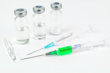 Green vaccine and two syringe on white background