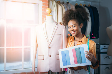 Portrait of fashion designer working in clothes in tailoring atelier. Tailor woman with fabric and clothing sketches at the office. fashion designs and handmade Concept