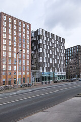 Fototapeta premium View of high-density residential and business area on the banks of the IJ River at the Oostelijke Handelskade (Eastern Docklands). Amsterdam, The Netherlands. 