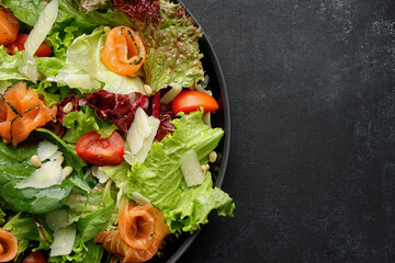Salad with salmon and parmesan cheese, in a plate