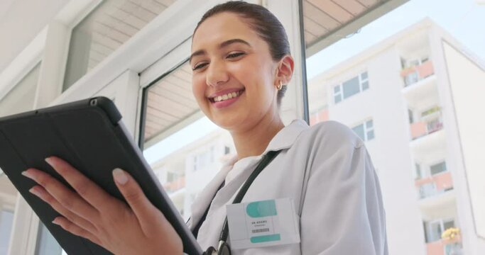 Digital tablet, research and woman doctor in the hospital browsing on the internet for memes while on break. Happy, laughing and female healthcare worker networking on mobile device in medical clinic