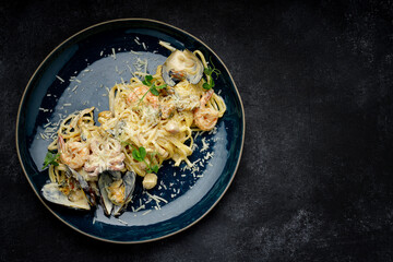 Spaghetti with seafood, mussels, shrimp, octopus, with sauce in a plate
