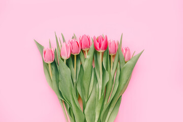 Bouquet of pink tulips on pink background. Mothers day, Valentines Day, Birthday celebration concept. Greeting card. Copy space for text, top view