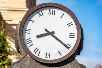 Fototapeta na wymiar Round street iron clock with arrows. Berlin, Germany.
